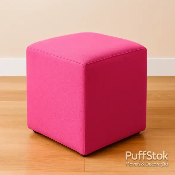 Puff quadrado rosa pink em tecido, sobre piso de madeira claro, com costuras alinhadas e acabamento premium.