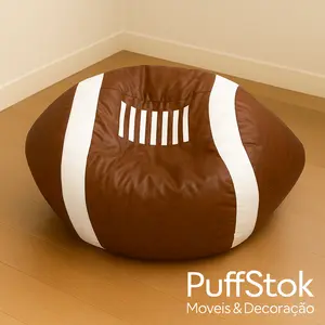 Puff com enchimento em formato de bola de futebol americano marrom, com listras brancas, sobre piso de madeira