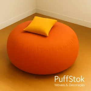 Puff gigante com enchimento em modelo redondo laranja sobre piso de madeira e, portanto, ideal para sala.