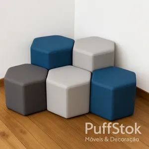 Conjunto de pufe hexagonais azul e cinza no canto da parede, sobre piso de madeira.